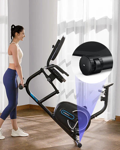 Mujer desplazando fácilmente una bicicleta estática reclinada Merach gracias a sus ruedas de transporte delanteras integradas en la base